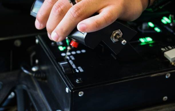 A young man holding a red-buttoned game controller in his hands